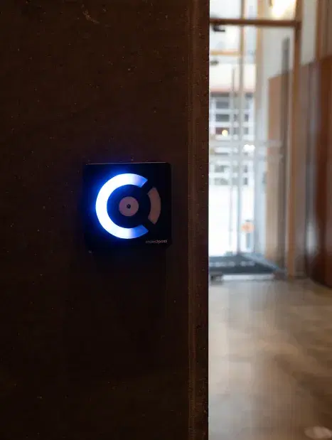 CrowdReader mounted on wall at venue entrance with blue LED ring